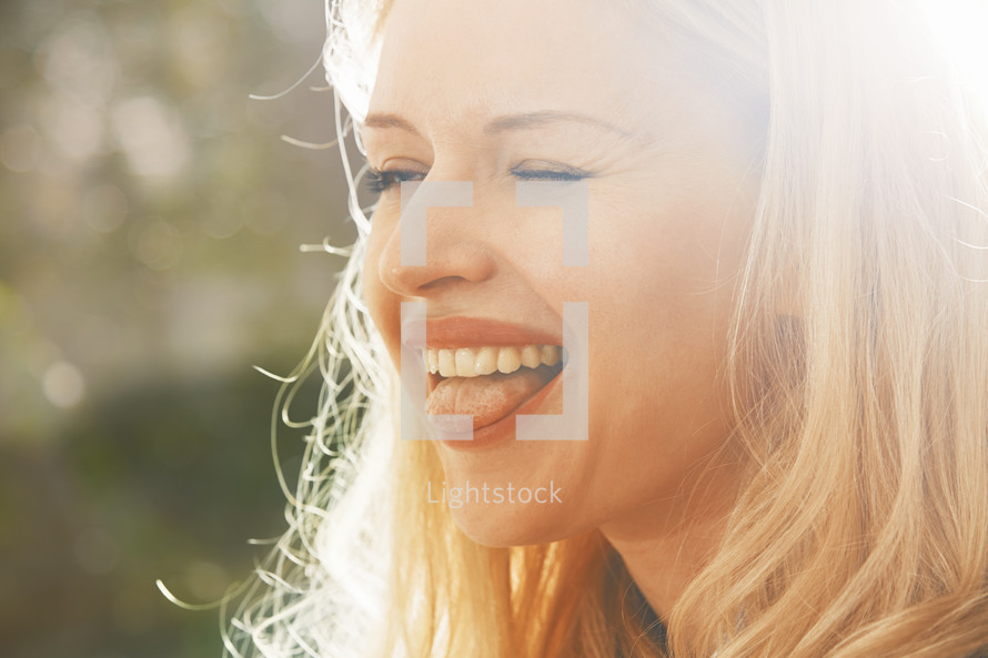 Carefree beautiful blond woman with long hair laughing