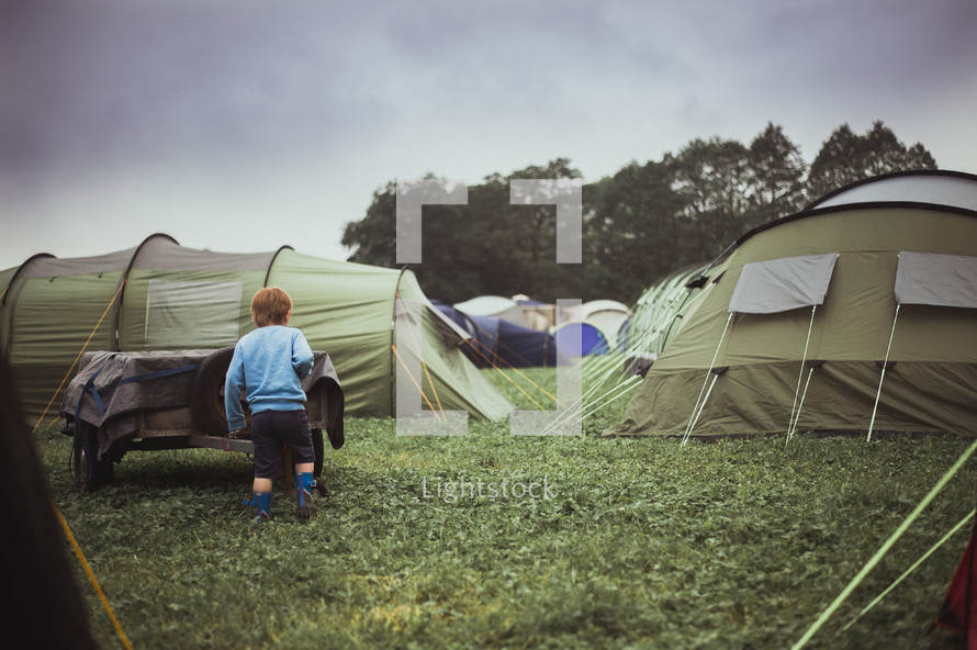 a boy standing in front of a tent 