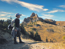 boy with backpack hiking in scenic mountains