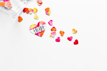 Top view of watercolor hearts scattered on white background with one labeled HEART. 