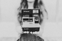 Woman holding Polaroid camera
