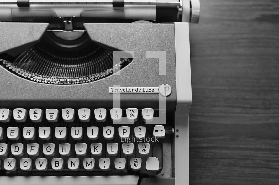 A black-and-white version of the old orange typewriter in this series. Close-up of keys, on wood backdrop.