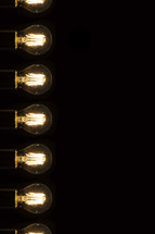 glowing filaments in lightbulbs in darkness 
