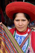 Peruvian woman holding woven blanket 