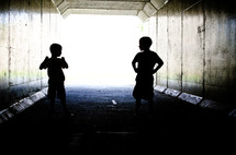 Silhouette of children playing in a tunnel.