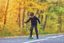 boy riding skateboard, outdoors in autumn environment on sunset warm light