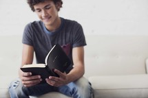 a teen boy reading a Bible 