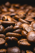 Close up from a bunch of coffee beans laying down. Backdrop for coffee products.