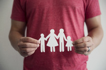 man holding a paper cutout of a family 