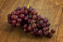 A cluster of grapes on a wooden table