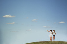 teen girls standing at the top of a hill