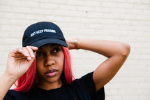 portrait of a young African American woman with Just Keep Praising Hat 