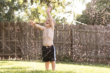 a toddler playing in a sprinkler 