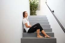 a tired woman sitting on steps 