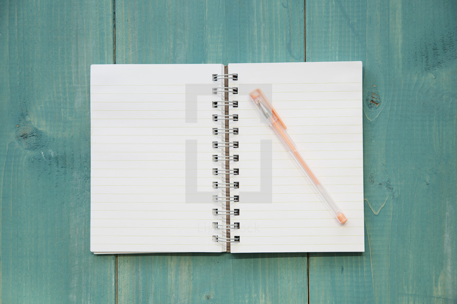 blank pages of a notebook on a teal wood background 
