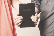 husband and wife holding a Bible together - Keep God in your marriage