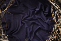 a crown of thorns on purple cloth.