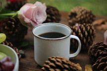 coffee in a mug and pine cones 