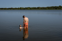 a father and son standing in a lake 