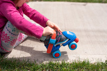 a child putting on roller skates 