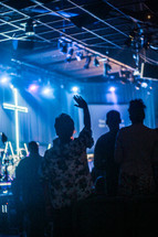 hands raised and musicians singing during a worship service 
