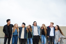 row of teens with arms around each other 