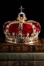 Kings Coronation Crown and Antique Books on a Black Background
