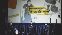 worship leaders on stage in front of a projection screen with Spanish lyrics 