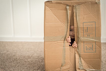 child playing with a cardboard box 