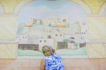 a woman painting a mural 