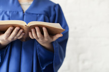 graduate holding a Bible 