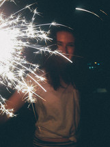 a girl holding a sparkler 