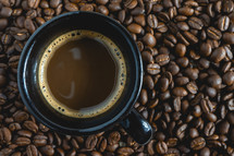 A fresh cup of coffee on a background of coffee beans.