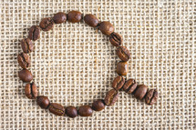 Coffee beans in the shape of a cup, on a burlap fabric. Background voor coffee related products.
