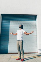 man with raised arms standing outdoors 