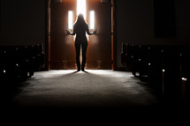 Silhouette of a woman leaving the church sanctuary. 