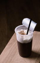 chocolate pudding with straw on wooden table