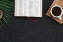 open Bible, coffee mug, and tray on a desk 
