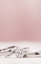 Macro View of Wedding Rings on a Wooden Table with Pink Background
