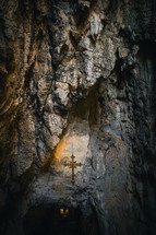 Crucifix hanging in a shrine in a cave