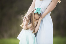 mother and daughter hugging outdoors 