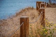 chains on posts forming a fence along a shore 