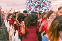 raised hands in prayer at a Christmas worship service 