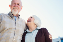 an elderly couple standing together 
