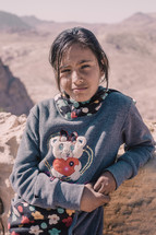 a girl standing in a desert 