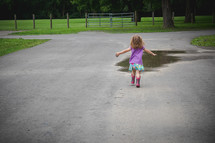 toddler running towards a puddle 