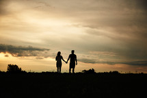 silhouette a couple holding hands at sunset 