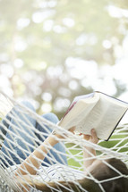 woman reading a Bible in a hammock 