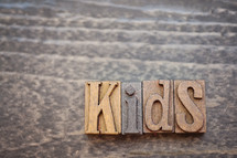 wooden print press stamps forming the word kids 