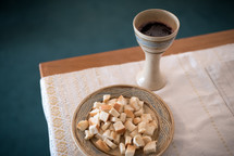 a chalice of wine and bowl of bread for communion 